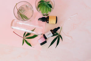 CBD oil bottles and hemp leaves flatlay