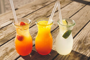 Three glass jars with colorful fruit drinks