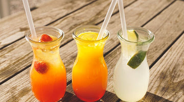 Three glass jars with colorful fruit drinks