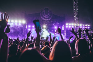 People raising hands at outdoor concert