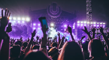 People raising hands at outdoor concert