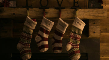 Christmas stockings hanging on rustic fireplace mantel