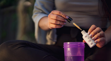Person adding serum to a purple cup