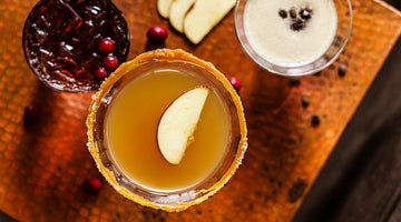 Three cocktails with apple slices and cranberries