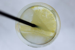 Lemon soda with ice and straw top-down