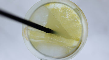 Lemon soda with ice and straw top-down
