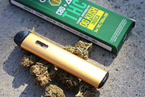 Gold vape pen with cannabis buds and green box