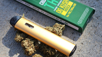 Gold vape pen with cannabis buds and green box