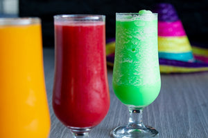 Three colorful drinks with a sombrero in background
