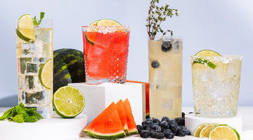 Four colorful cocktails with lime, watermelon, and blueberries